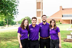 Natasha, Cooper, Jacob, and Kristen stand with arms around eachother with the bell tower in the background